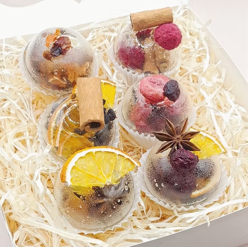 Six tea spheres with cinnamon, orange, berries and star anise in a gift box