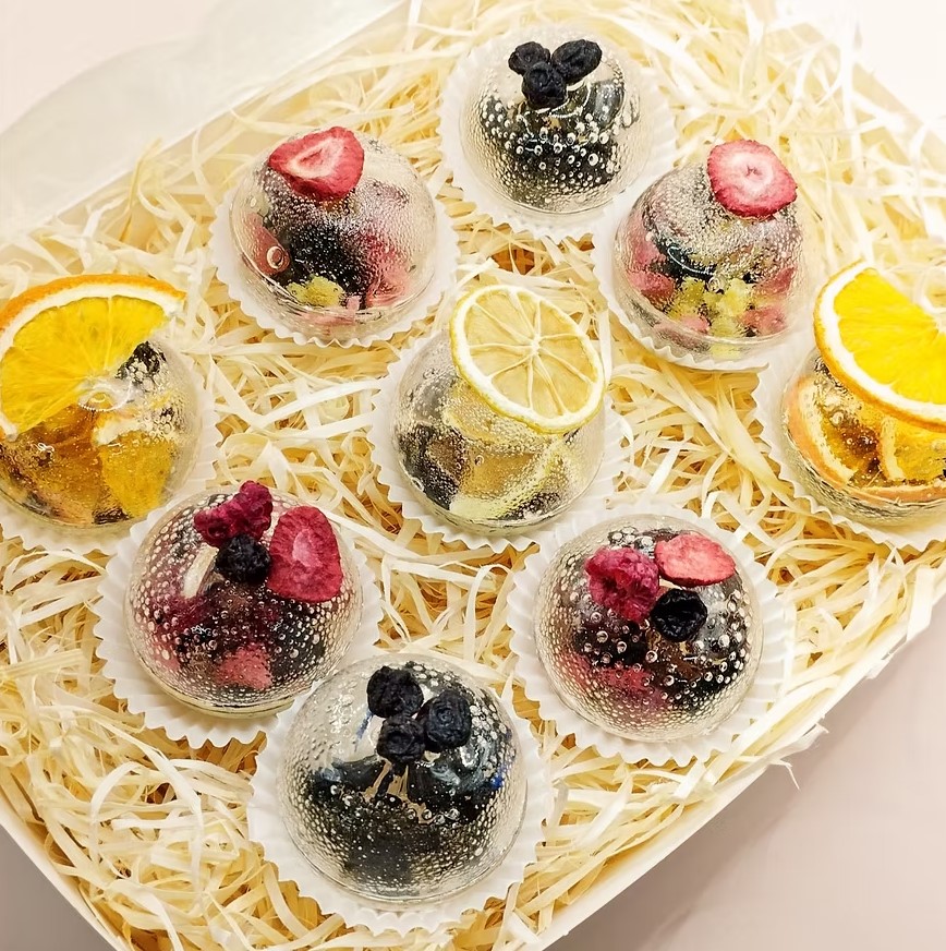 Nine fruit tea spheres with orange, lemon, strawberry, raspberry and blueberry in a box
